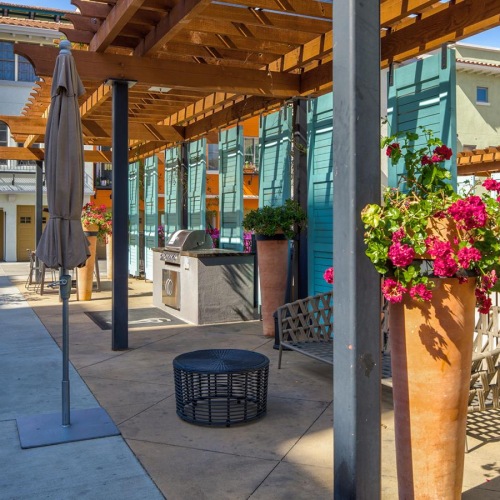 Settle into comfort at Santana Row a sidewalk with potted plants and outdoor grill